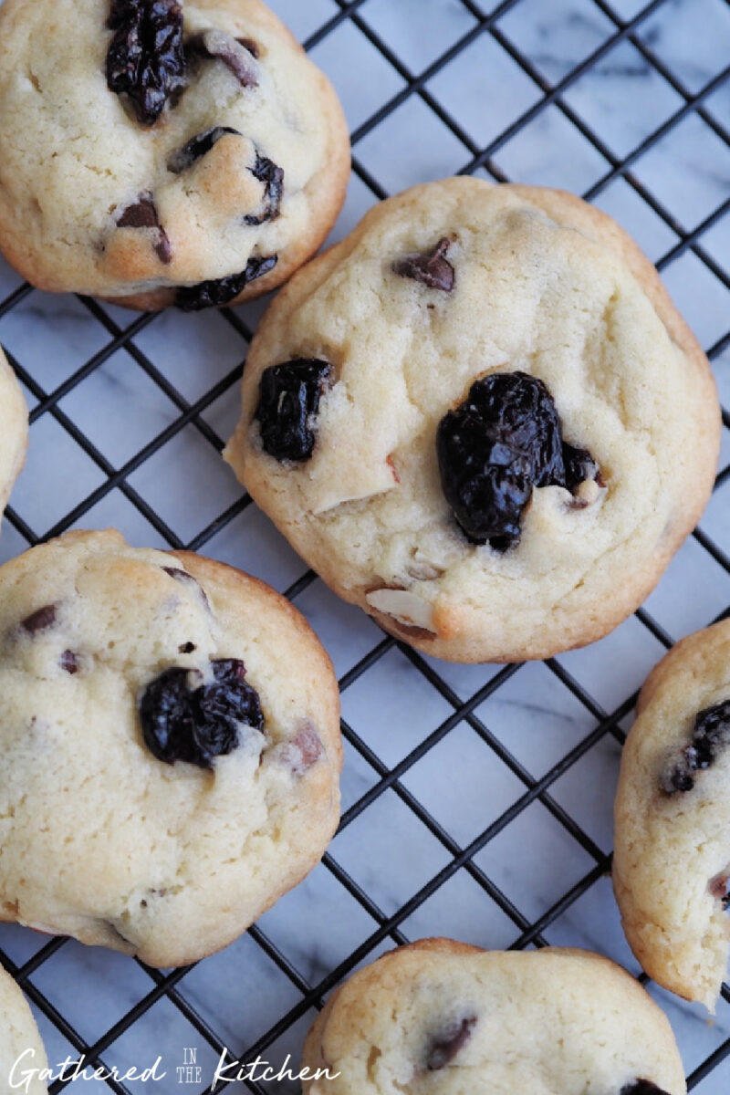 Soft and chewy cherry almond chocolate chip cookies on a cooling rack | Gathered In The Kitchen 