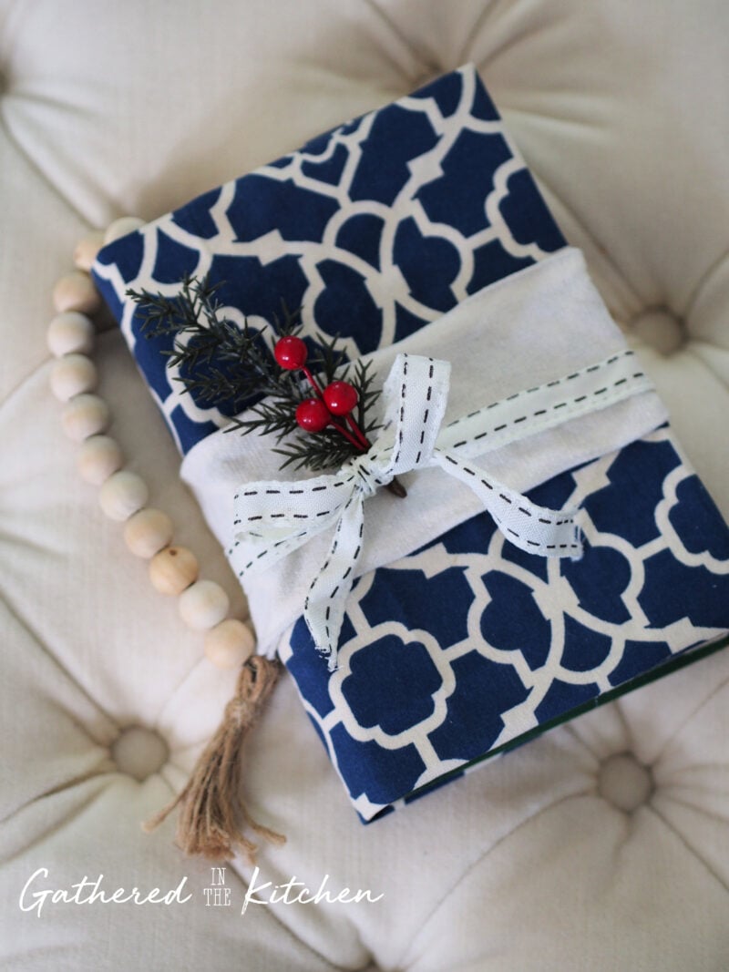 Learn how to make a DIY no-sew fabric book cover. This step-by-step tutorial shows how to measure, fold, and glue fabric into a reusable DIY book sleeve.