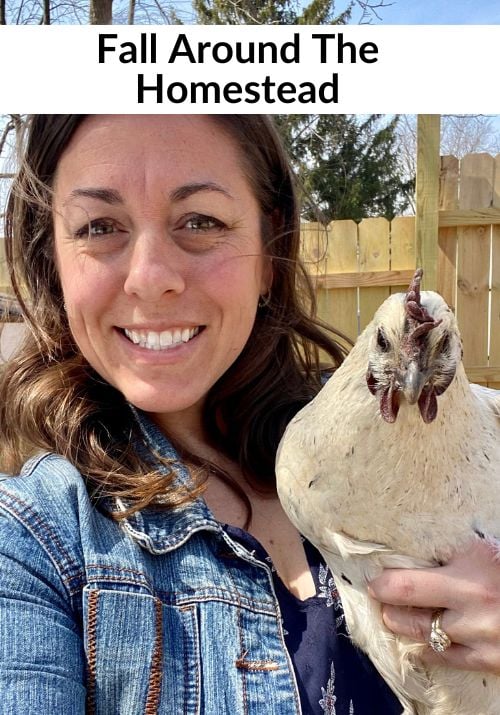Stephanie from Gathered In The Kitchen in a jean jacket holding a backyard chicken, sharing fall homestead living. 