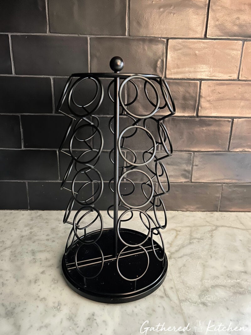 Empty Keurig K Cup holder on a white counter before being repurposed into a DIY home organizer. | Gathered In The Kitchen