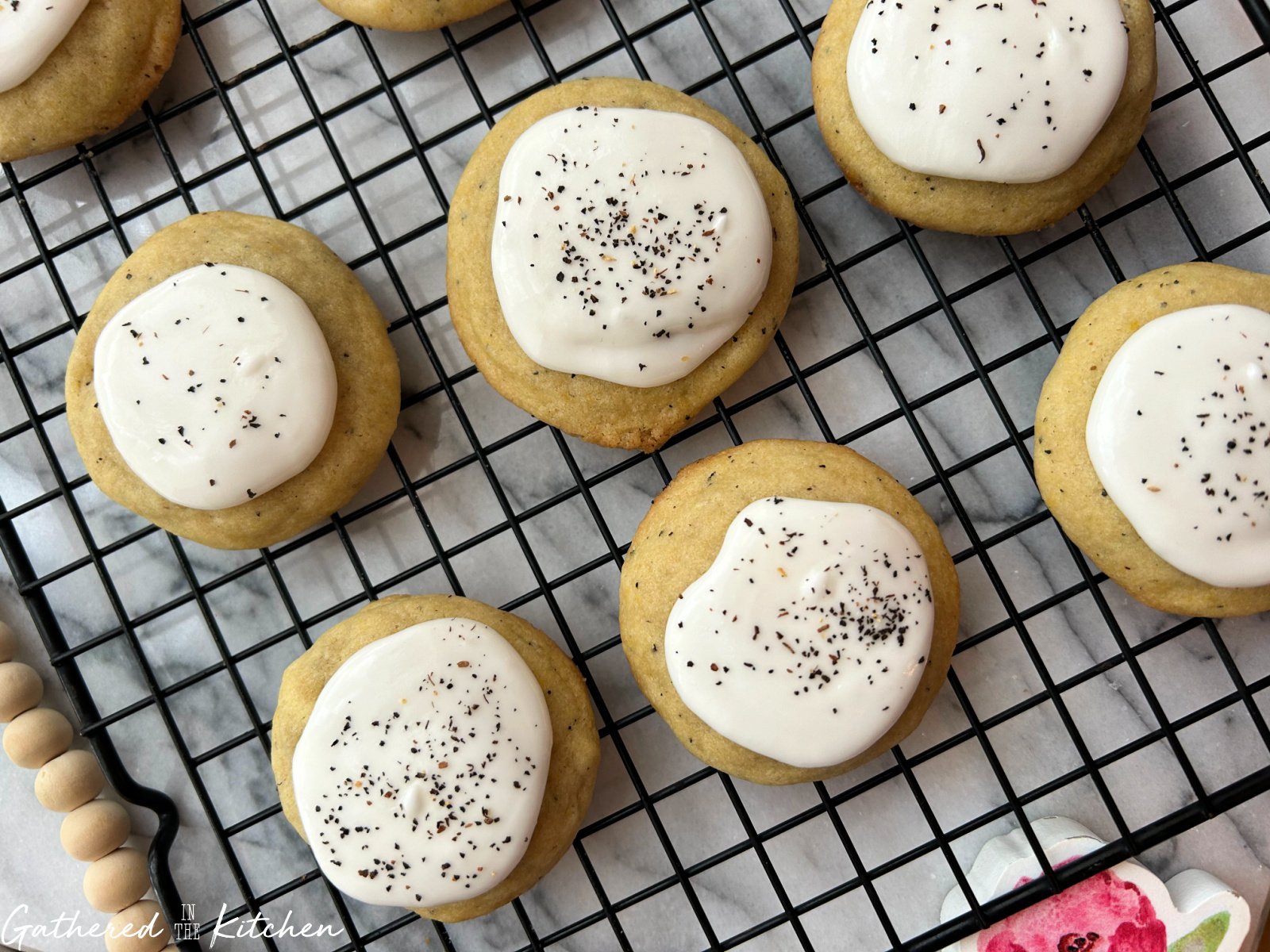 Chai sugar cookies topped with vanilla icing and chai spice cooling on a wire rack. | Gathered In The Kitchen