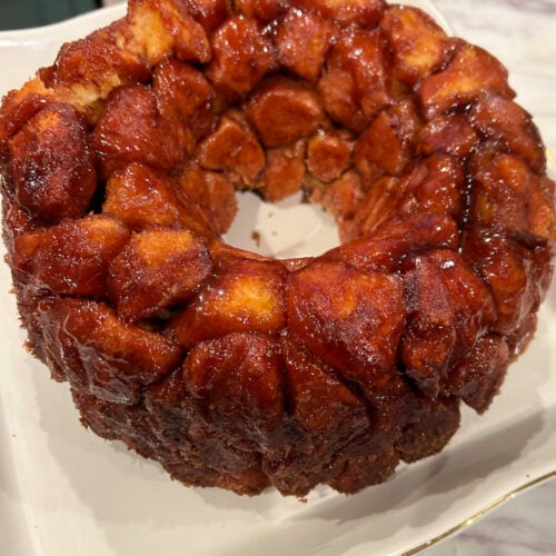 Gooey baked monkey bread made with canned biscuits and cinnamon sugar, served as a pull-apart breakfast bread. | Gathered In The Kitchen