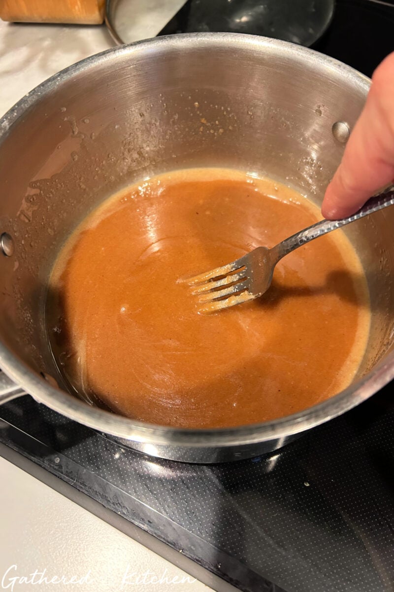 Melted brown sugar butter glaze cooking in saucepan for monkey bread. | Gathered In The Kitchen 