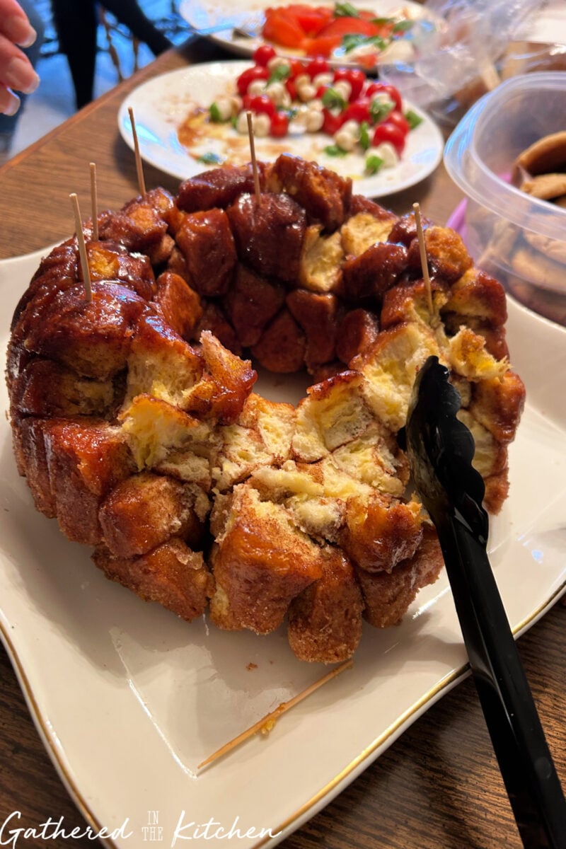 Close-up of gooey cinnamon sugar pull-apart monkey bread being served. | Gathered In The Kitchen 