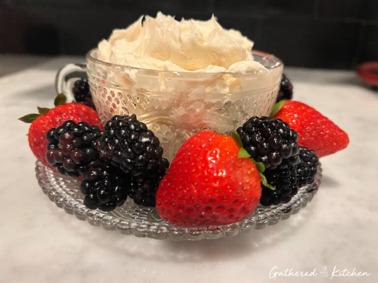 Cream cheese fruit dip in a clear glass bowl served on a platter with fresh strawberries and blackberries. | Gathered In The Kitchen