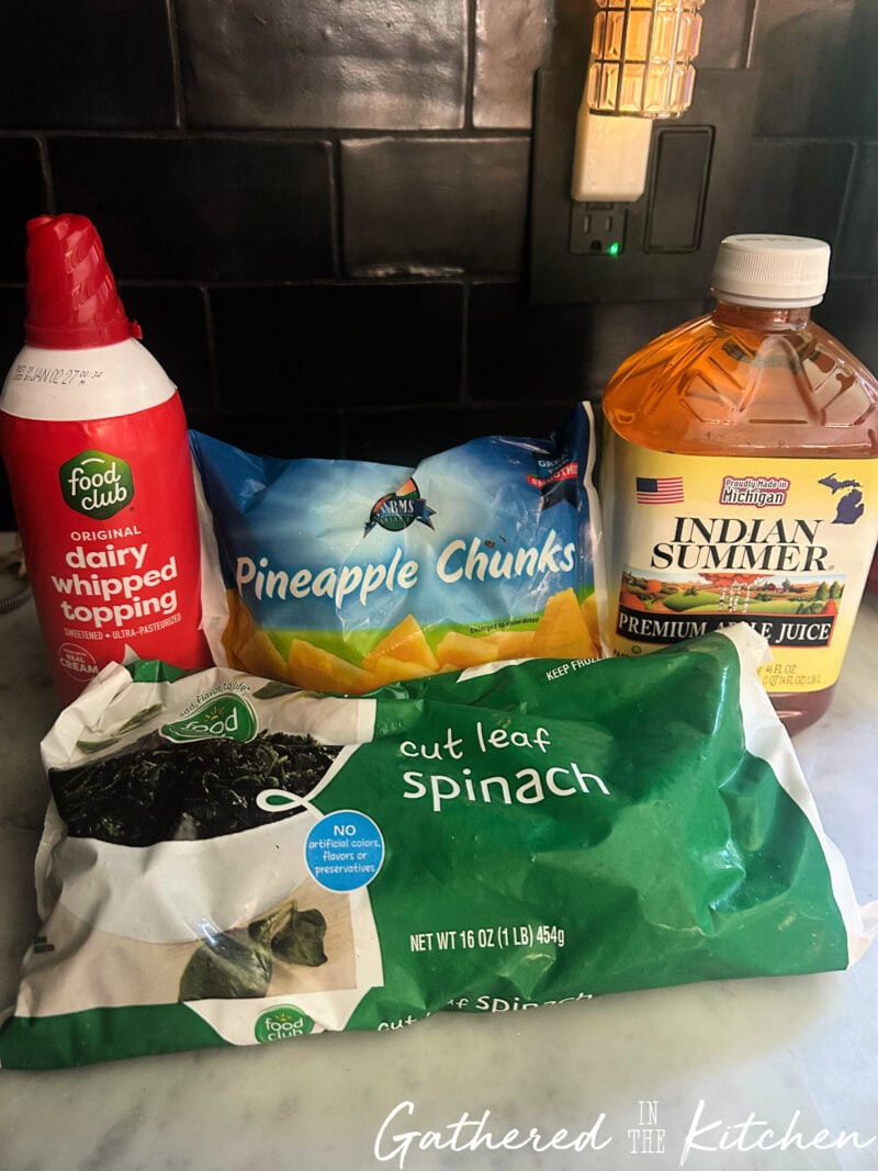 Frozen cut leaf spinach, frozen pineapple chunks, apple juice and whipped topping used to make a green smoothie | Gathered In The Kitchen